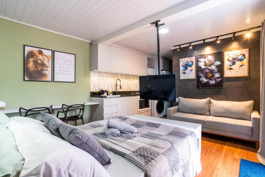 a bedroom with a bed and a couch in a room at Studio c AC, Piscina e Café Novo Hamburgo in Novo Hamburgo