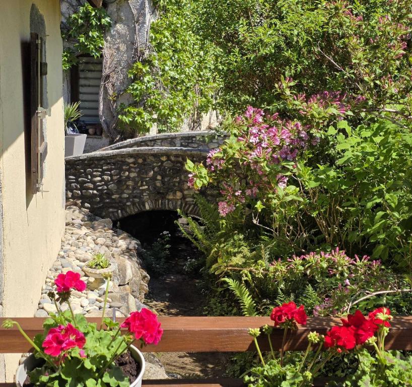 a garden with flowers and a stone bridge at Le Moulin de mes garçons in Alby