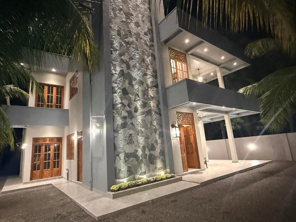 a building with two doors and a stone wall at The Ceylon Slate in Tangalle