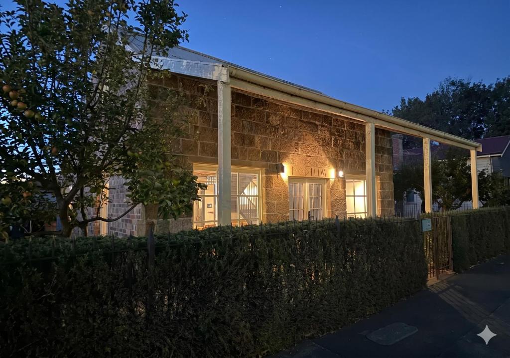 a brick house with the lights on at night at The Podium Accommodation - Oatlands, Tasmania in Oatlands