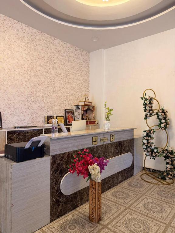 a lobby with a reception desk with flowers on it at The Royal Vintage Resort in Majhola