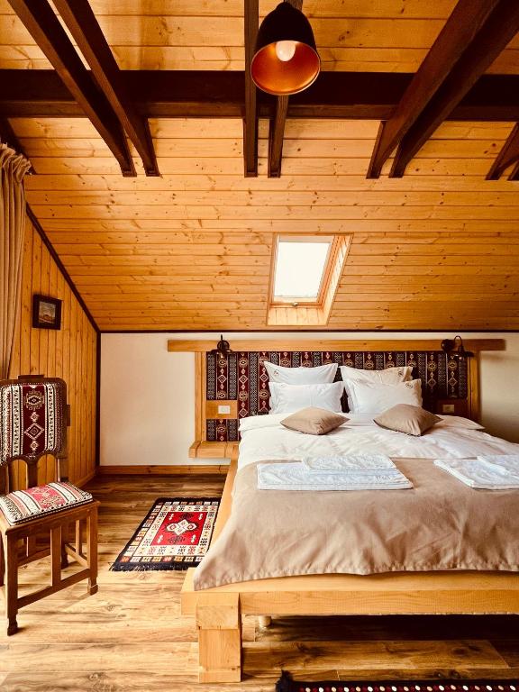 a bedroom with a large bed in a wooden room at Domeniul Mortasifu in Nişcov