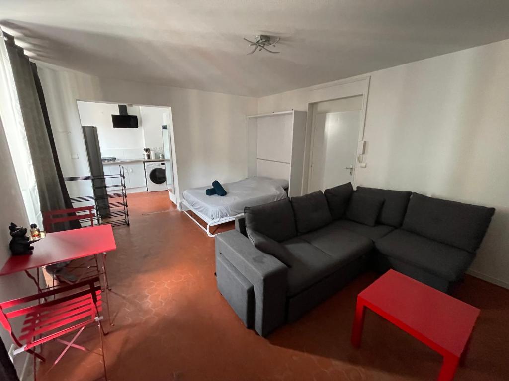 a living room with a couch and a bed at studio idealement situé in Marseille