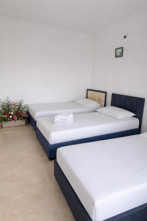a row of four beds in a room at Airport Double Room in Kamëz