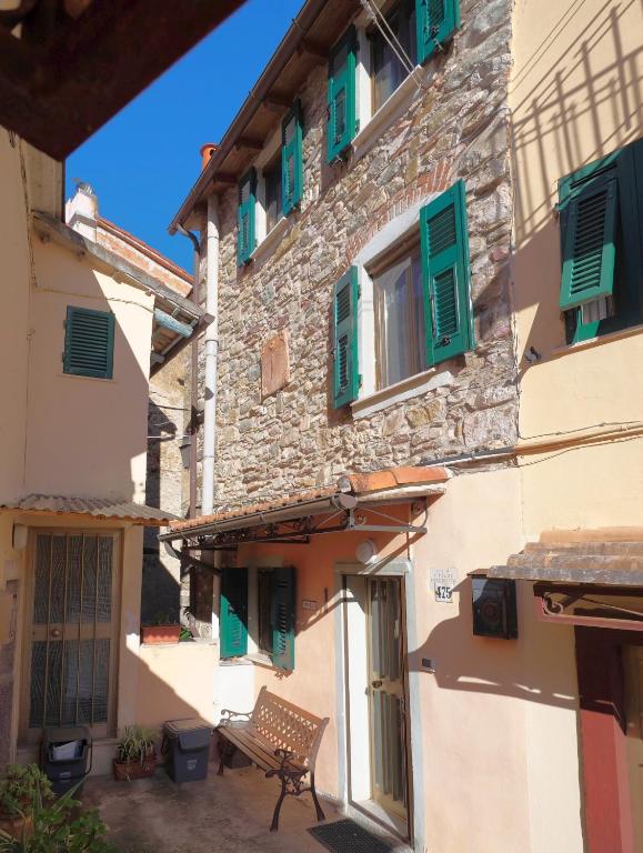 a bench sitting outside of a building with green shutters at Casa Paola 5 Terre in Biassa