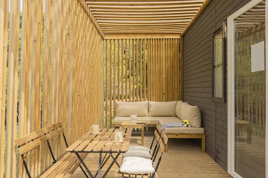 a patio with a bench and a table and a couch at Sènia Botànic Bonavista in Calella