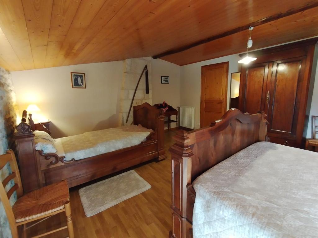 a bedroom with two beds and a wooden ceiling at Le Logis de bouillé in Bouillé-Courdault