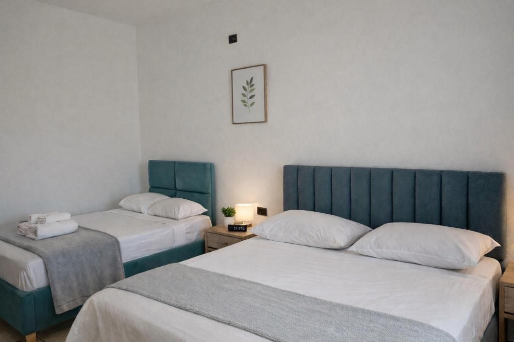 two beds in a room with two beds sidx sidx sidx sidx at Spacious Triple Room with Balcony in Kamëz