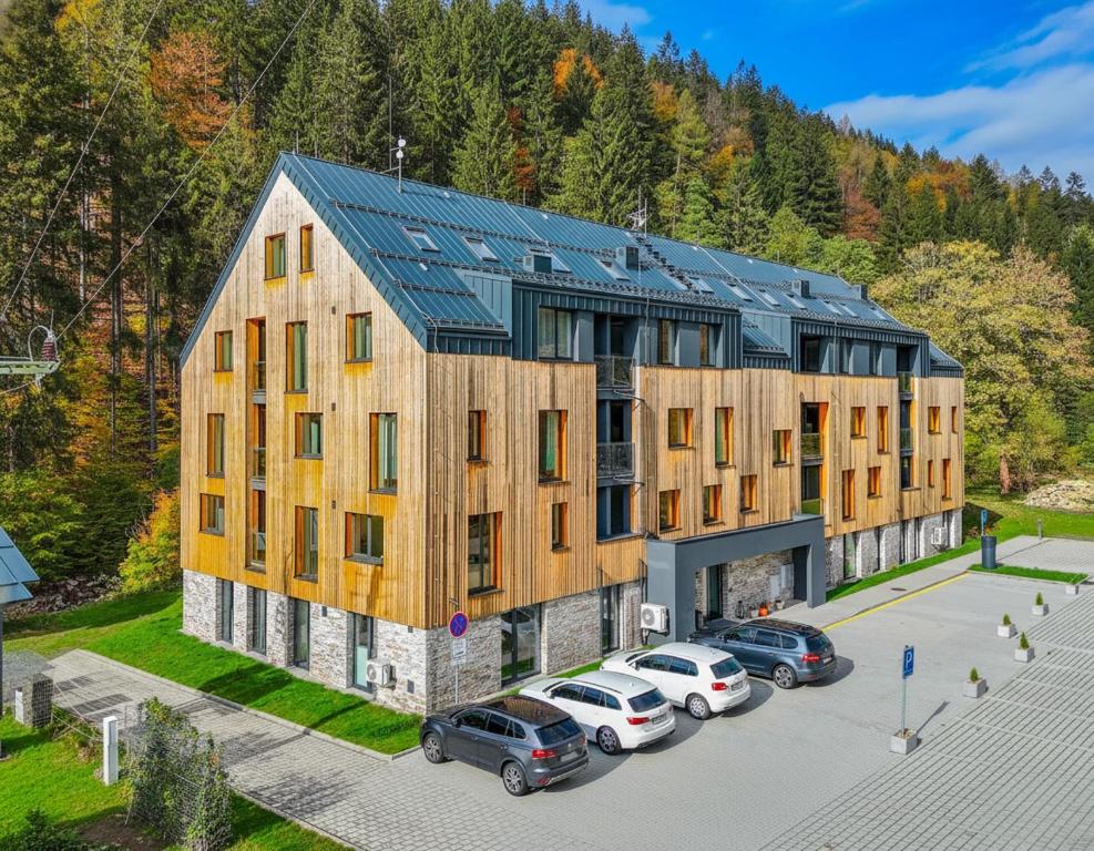 a large building with cars parked in a parking lot at Apartmán Mlýn 208 in Vrchlabí