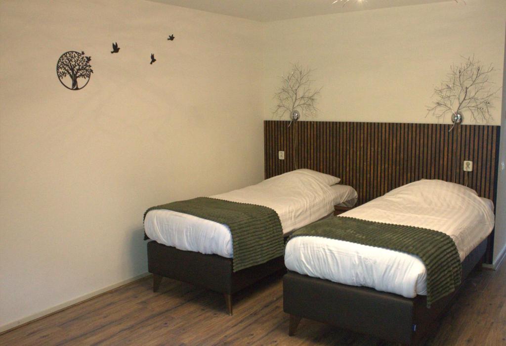 two beds in a room with two bedsskirts at Hotel Studio Bosch Duin Strand in Den Helder