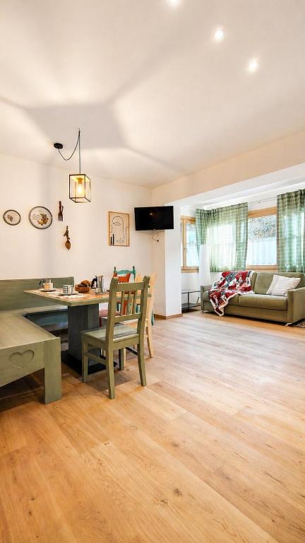 a living room with a table and a couch at Verde Betulla, Free Park and Ski room in Camporosso in Valcanale