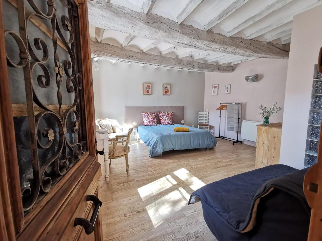 a bedroom with a bed and a table in a room at Gîtes Chambres d'hôtes de charme B&B - La Cense du Pont - Campagne de Lille in Bachy