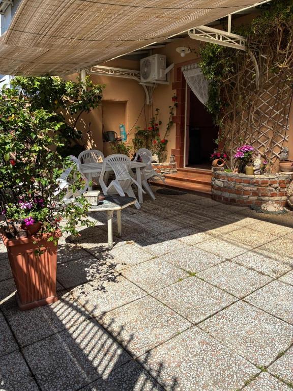 eine Terrasse mit Tisch und Stühlen und ein Gebäude in der Unterkunft Clio 21 in Marina di Massa