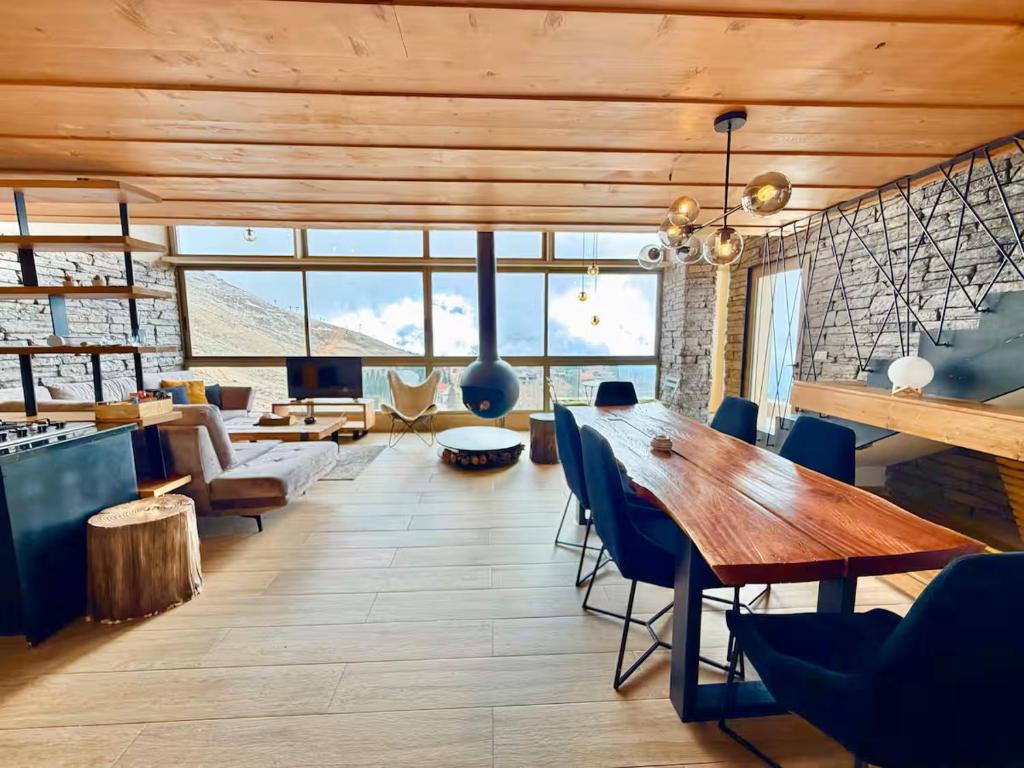 a living room with a large wooden table and chairs at Alto Faqra in Brummānā