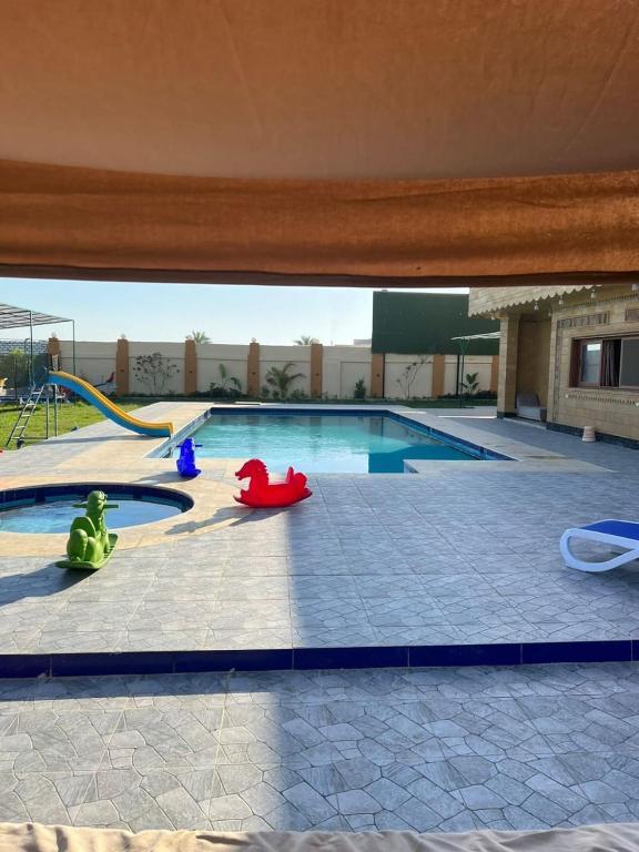 a swimming pool with some toys in front of it at Villa Layan الريف الاوروبي in Madīnat as Sādāt