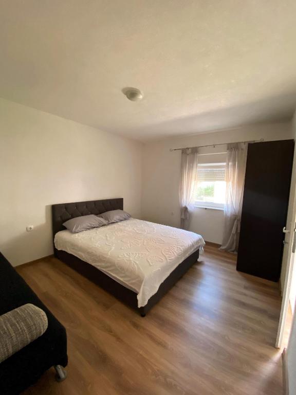 a bedroom with a bed and a wooden floor at Stan na dan Harmonija in Nevesinje