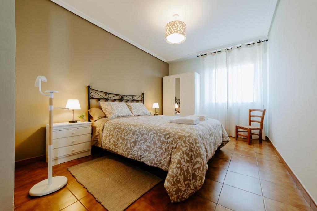 a bedroom with a bed and a table and a chair at Casa Raíces de PO in Lapoblación