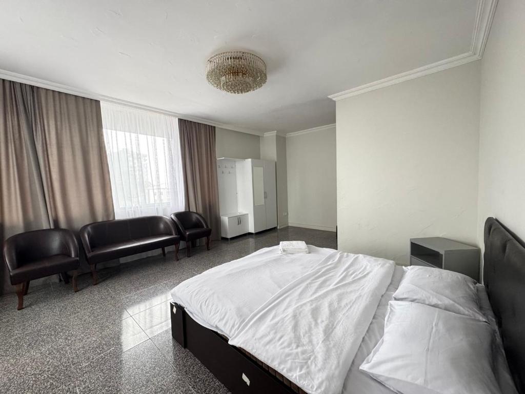 a bedroom with a bed and chairs in it at Family Hotel in Batumi