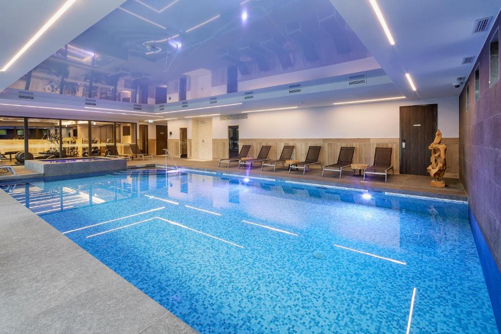 a large swimming pool with blue water in a building at Van der Valk Hotel Breda in Breda