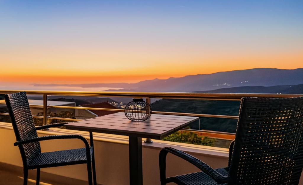 a table and two chairs on a balcony with the sunset at Liopetro in Sitia