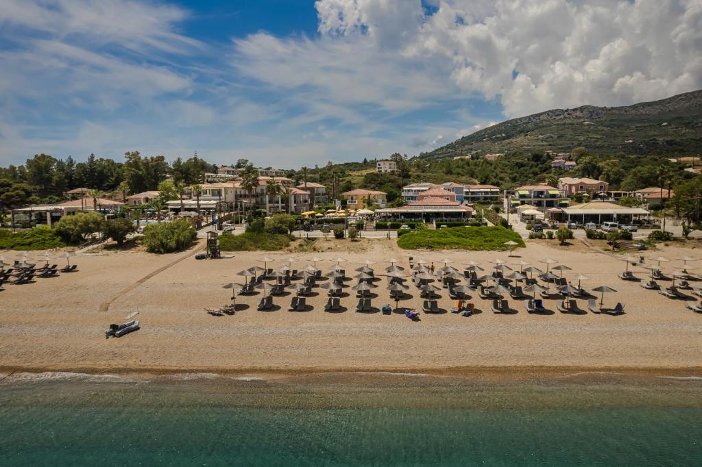 Luftaufnahme eines Strandes mit Liegestühlen und dem Meer in der Unterkunft Paspalis Hotel in Skala