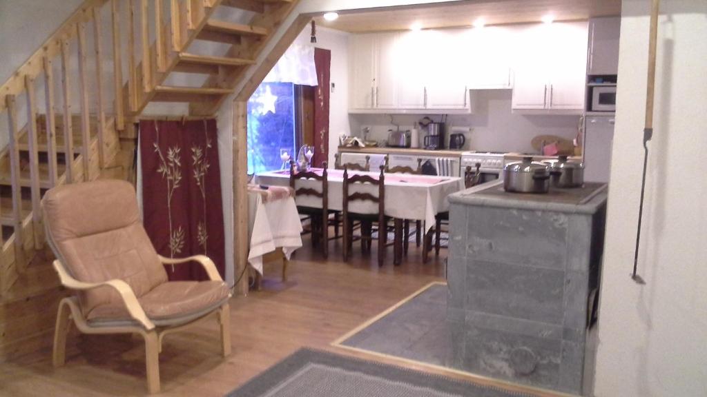 cocina y comedor con escalera y mesa en Aamuruskon Holiday Home, en Lankojärvi