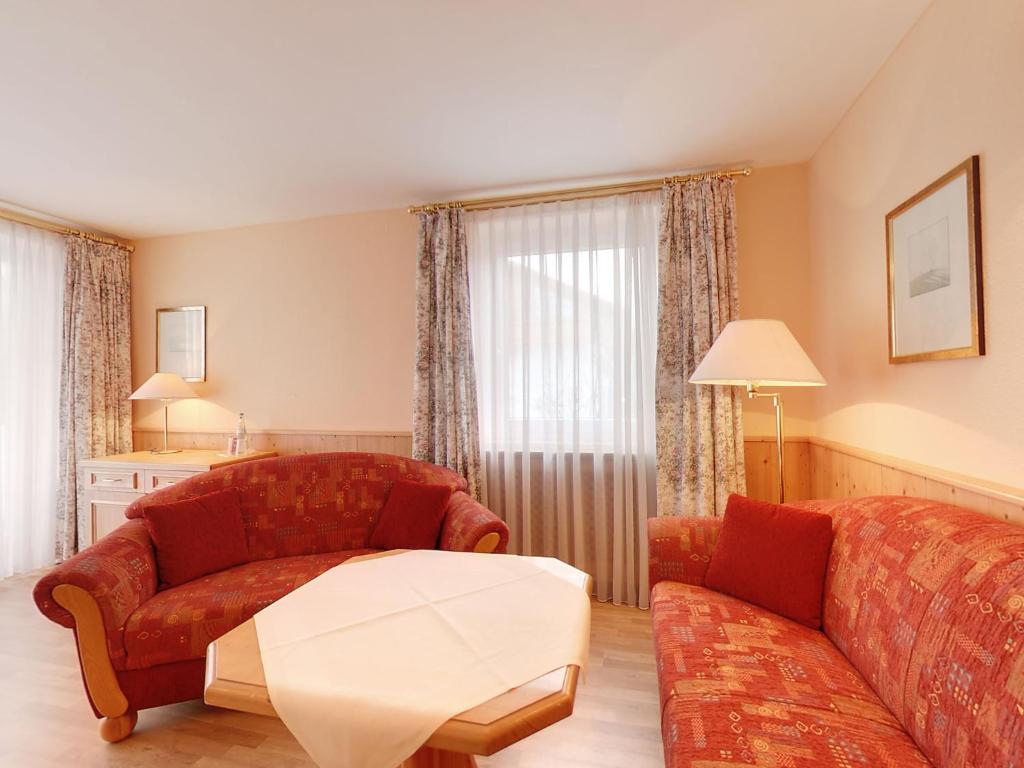 ein Wohnzimmer mit einem Sofa und einem Tisch in der Unterkunft Hotel Resi von der Post in Bad Wiessee