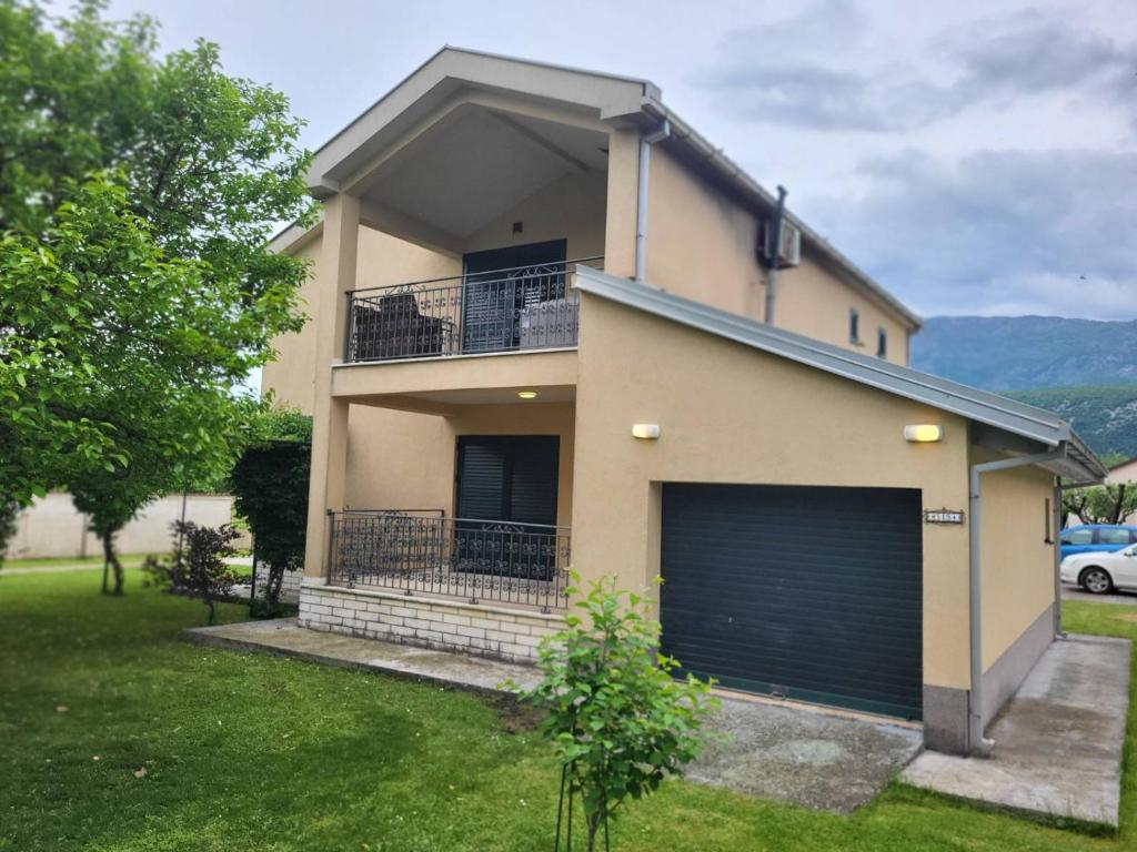 a house with two garage doors and a car at Green Oasis in Danilovgrad