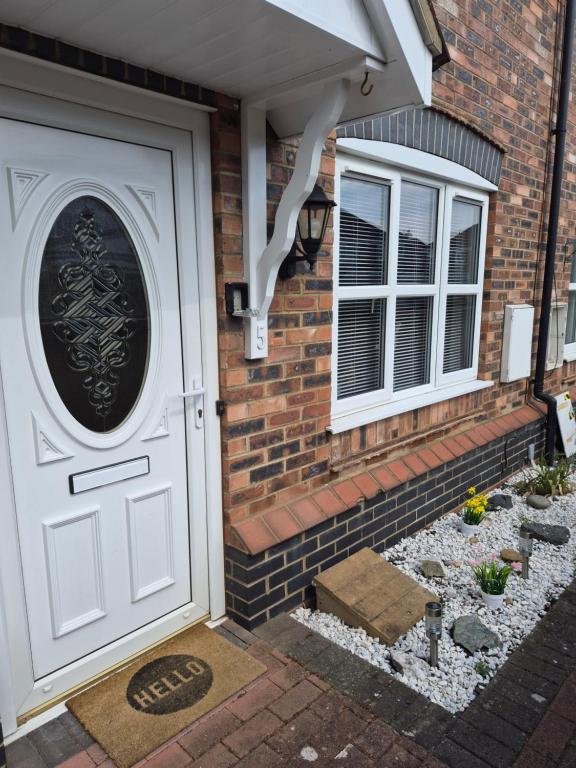 a brick house with a white door and windows at Highwood mews in Cleethorpes