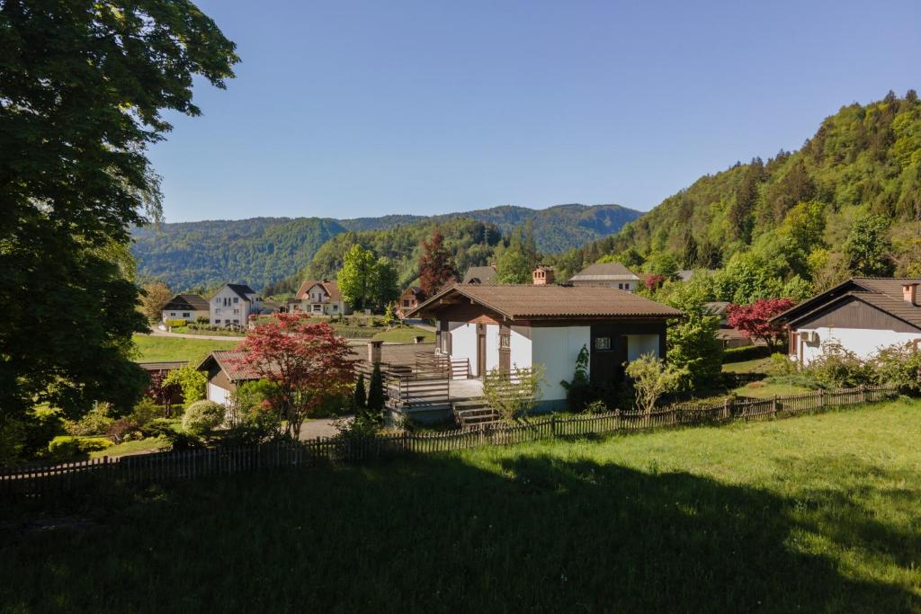a house in the middle of a yard with mountains in the background at Cosy Vintage House Bled in Bled