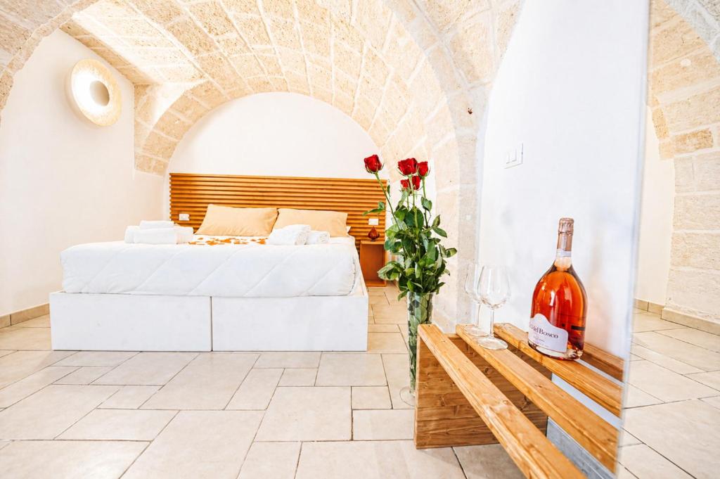a bedroom with a bed and a bottle of wine at Palazzo Kapece in Monopoli