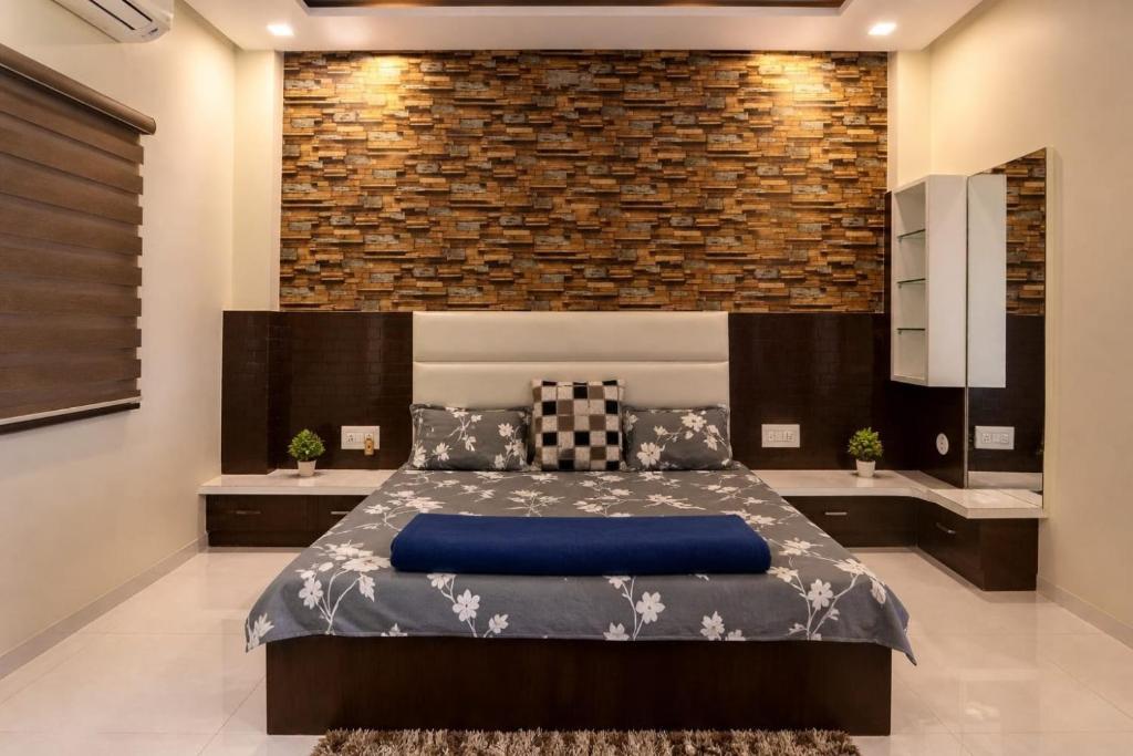 a bedroom with a bed and a brick wall at Shivlok Homestay in Ujjain