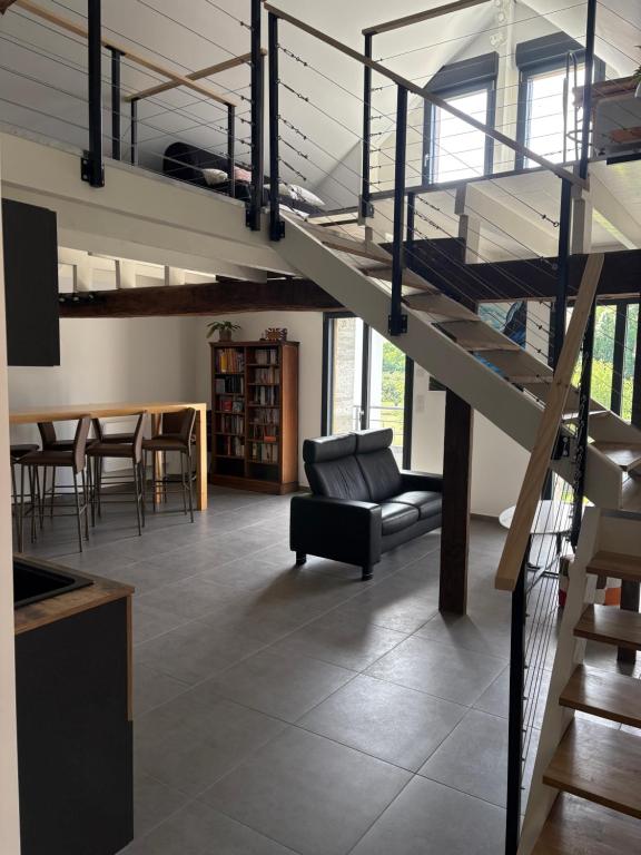 a living room with a staircase and a couch and a table at La Fraternelle in Ceyzérieu