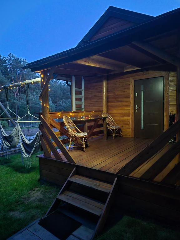 a large wooden deck with a table and chairs at Pod lasem Celina Burda in Majdan Sopocki
