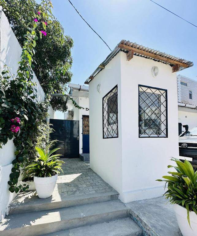 a white house with plants in front of it at Villa Almadies in Pointe-Noire