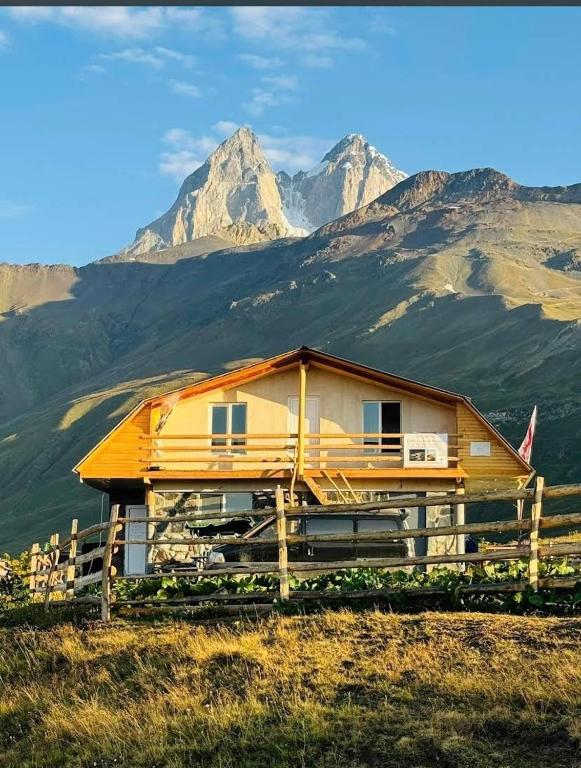 a house on a hill with mountains in the background at სასტუმრო ქორულდი / Hotel Koruldi in Mestia