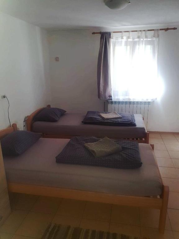 two beds in a room with a window at Room AIKA in Tolmin