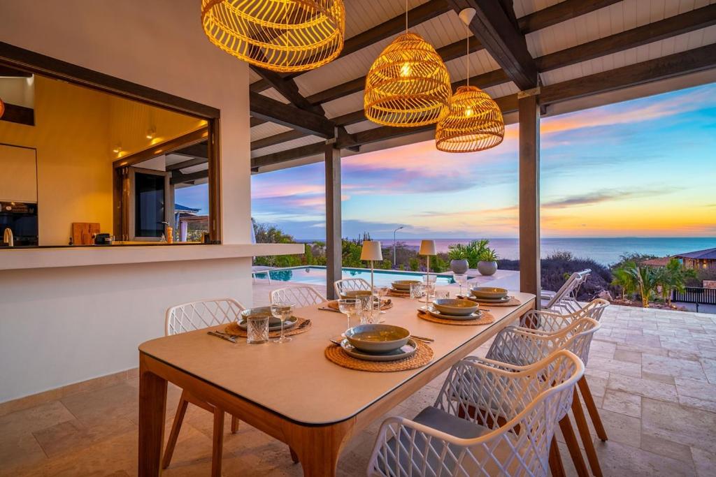 a dining room with a table and chairs at Luxe Villa met Panoramisch Zeezicht op Bonaire - Kas Ubuntu in Kralendijk