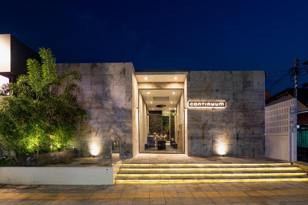 a building with stairs leading to the entrance at night at Continuum Hotel Udonthani in Udon Thani