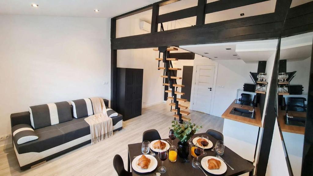 a living room with a loft bed and a table with pancakes at Dream Apartments 1B KLIMATYZACJA in Oświęcim