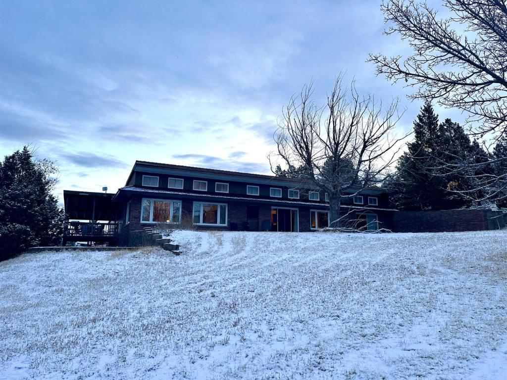 a house with snow on the ground in front of it at Charming, Spacious, Contemporary Mountain Retreat in Whitehall