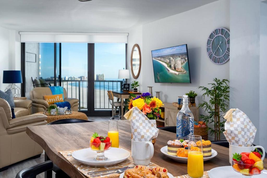a living room with a table with food on it at Waterfront Condo Beach Access & Pool Luxury in Marco Island