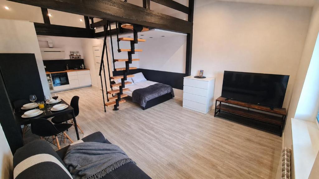 a living room with a loft bed and a tv at Dream Apartments 3B KLIMATYZACJA in Oświęcim