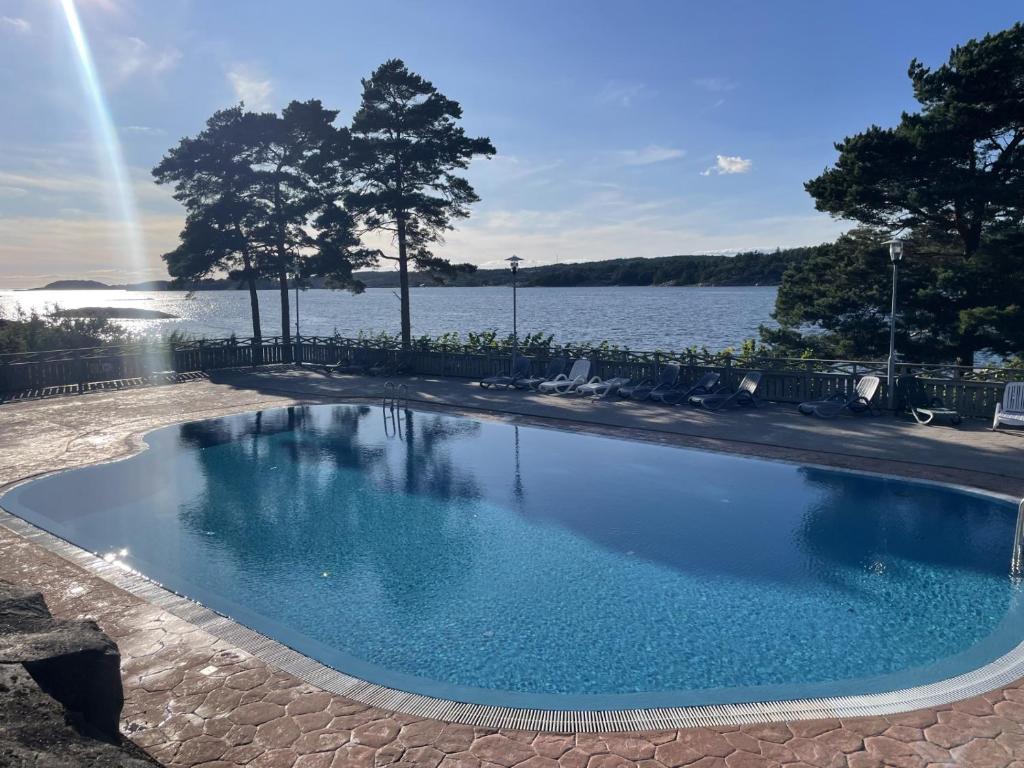 a swimming pool next to a body of water at Lägenhet i Strömstad in Strömstad