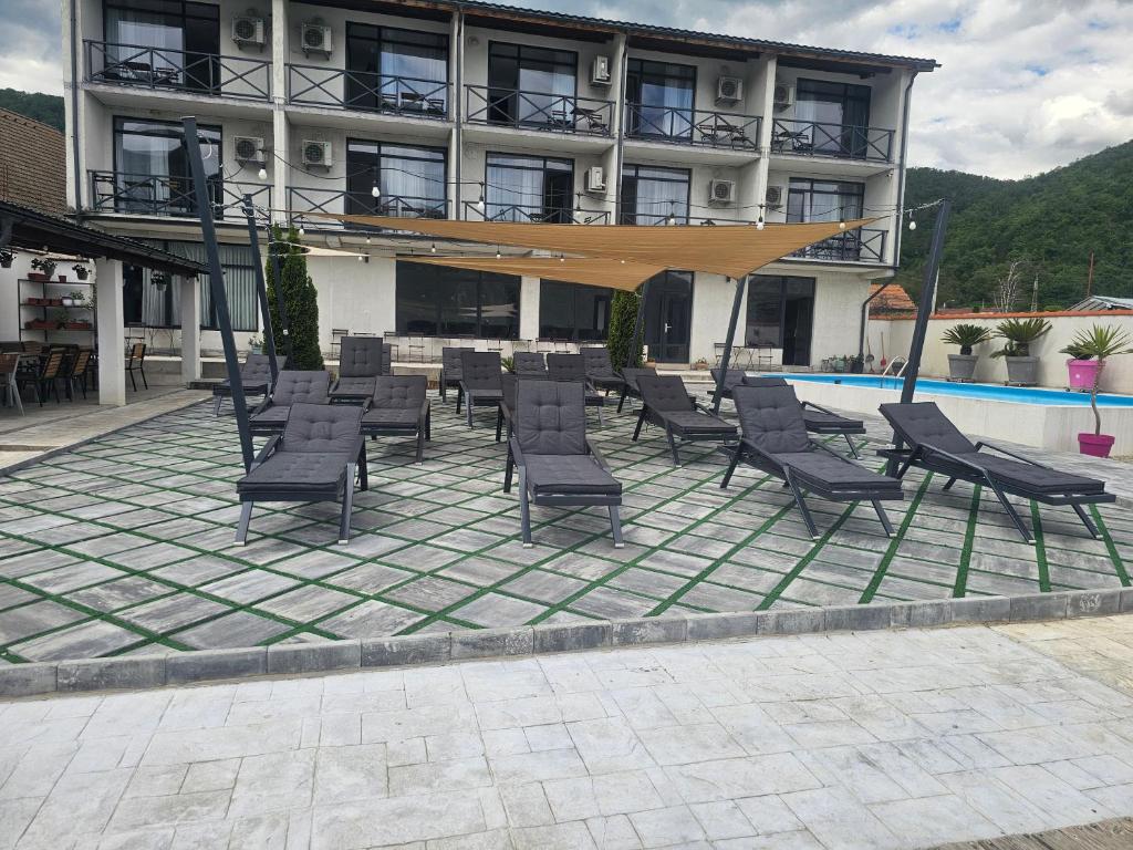 a group of chairs on a patio in front of a building at Vila La Faleza Dubova in Dubova