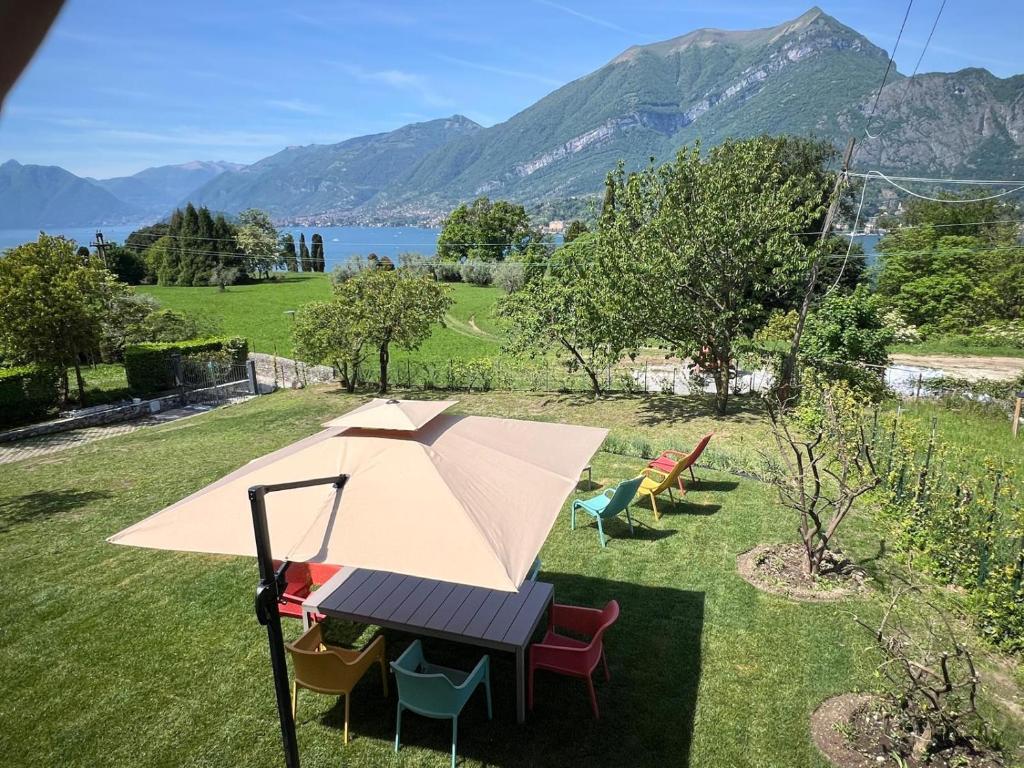 a table and chairs with an umbrella in the grass at Villa Viadeipini22 in Bellagio