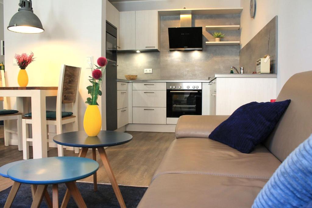 a living room and kitchen with a couch and a table at Bernstein Suite & Breakfast Apartment 05 in Büsum
