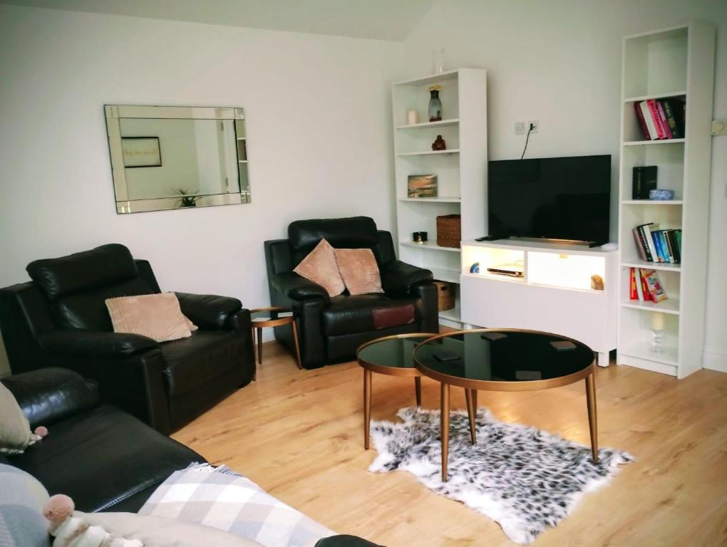 a living room with two black chairs and a television at Hillview in Royaloak