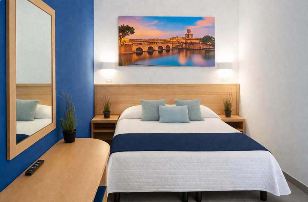 ein Schlafzimmer mit einem Bett und einem Gemälde an der Wand in der Unterkunft Hotel Aldebaran - Ideale per Gruppi - Marina Centro in Rimini