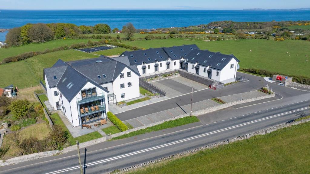 an aerial view of a large white house on a road at Glynllifon 7 in Llanallgo